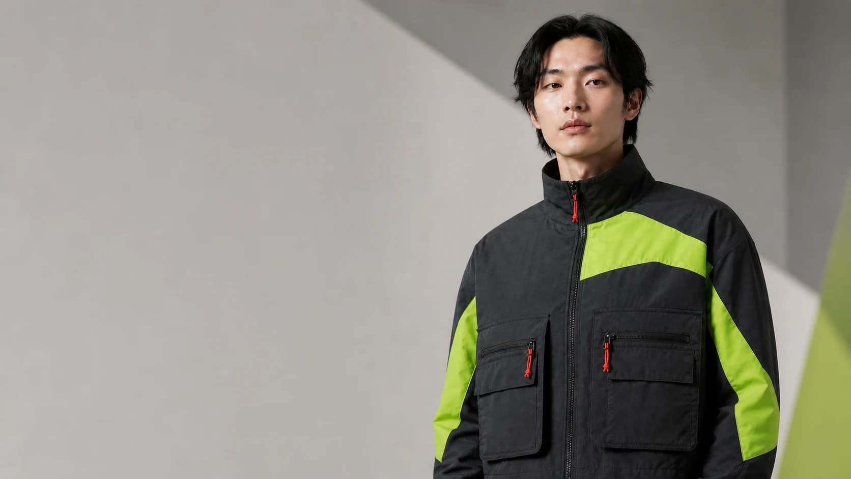 Adult model wearing the charcoal utility jacket in a wide campaign image